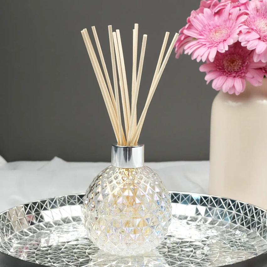 Bouteille vide transparente avec bâtons diffuseurs dans une boîte à Woodbridge Candle